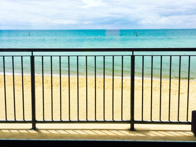 Photo scenic view of sea against sky seen through fence