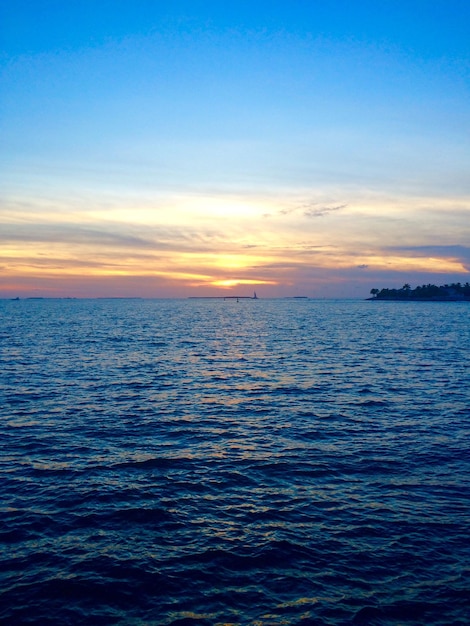 Photo scenic view of sea against sky at sunset