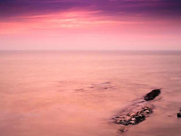 Photo scenic view of sea against sky at sunset