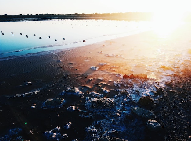 Photo scenic view of sea against sky at sunset