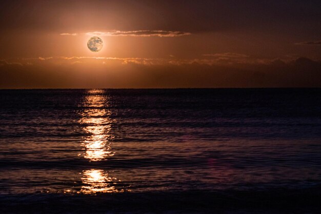 Photo scenic view of sea against sky at sunset