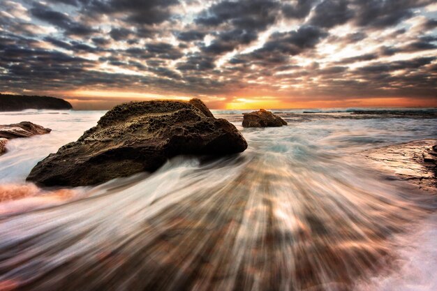 Photo scenic view of sea against sky at sunset