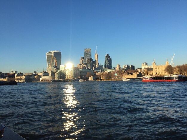 Scenic view of sea and buildings against clear blue sky