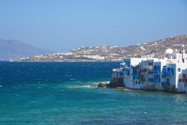 Photo scenic view of sea and buildings against clear blue sky