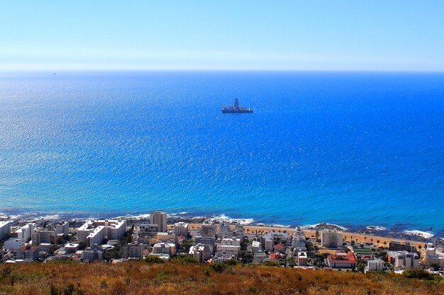 Scenic view of sea by buildings against blue sky