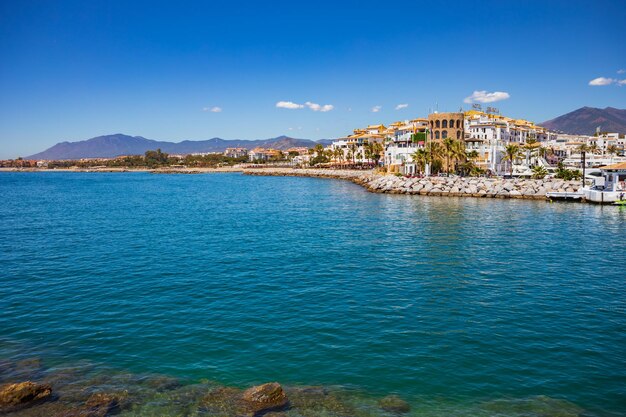 Scenic view of sea by buildings against blue sky