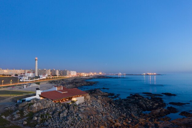 Scenic view of sea by buildings against clear blue sky