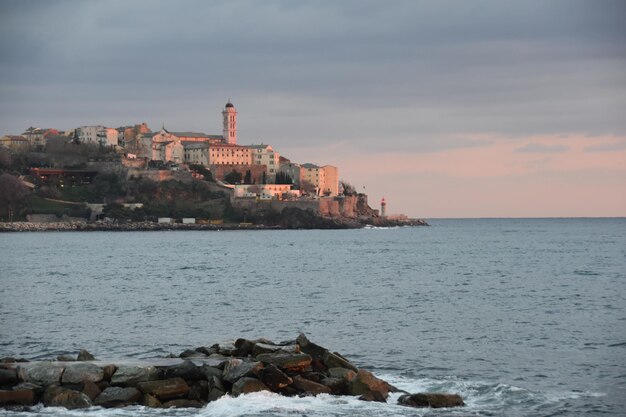 Scenic view of sea by buildings against sky