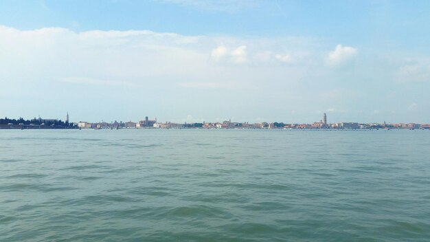 Scenic view of sea by buildings against sky