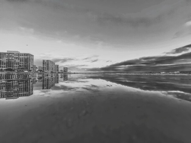 Scenic view of sea by buildings against sky