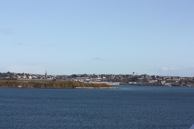 Scenic view of sea by city against sky