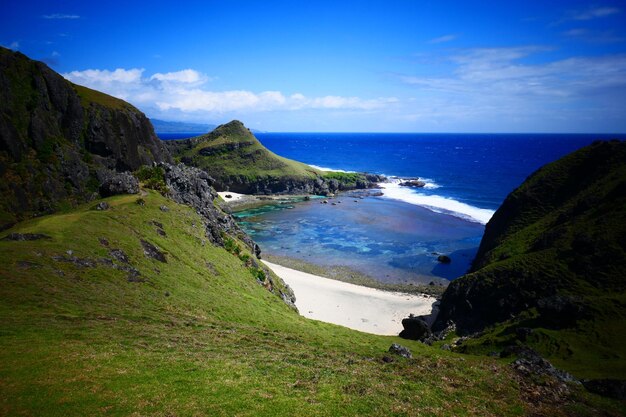 Scenic view of sea by cliff against sky