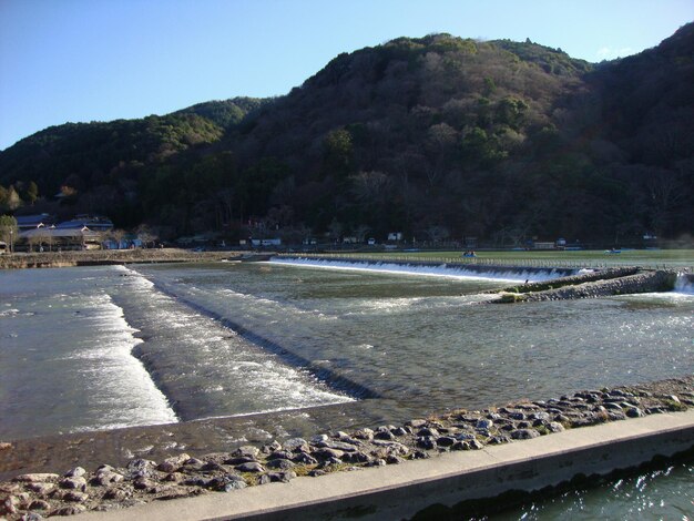 Scenic view of sea by mountains against clear sky