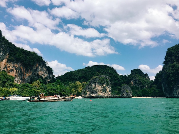 Scenic view of sea by mountains against cloudy sky