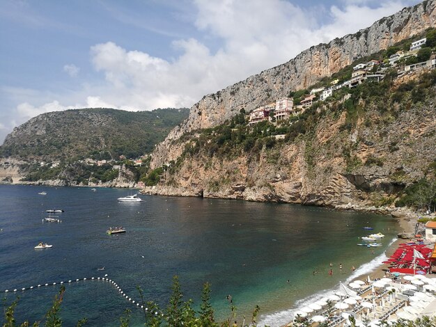 Photo scenic view of sea by mountains against sky