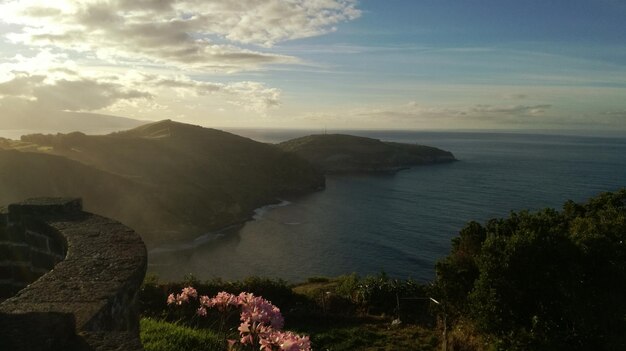 Photo scenic view of sea by mountains against sky