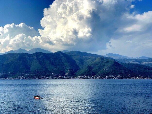 Scenic view of sea by mountains against sky