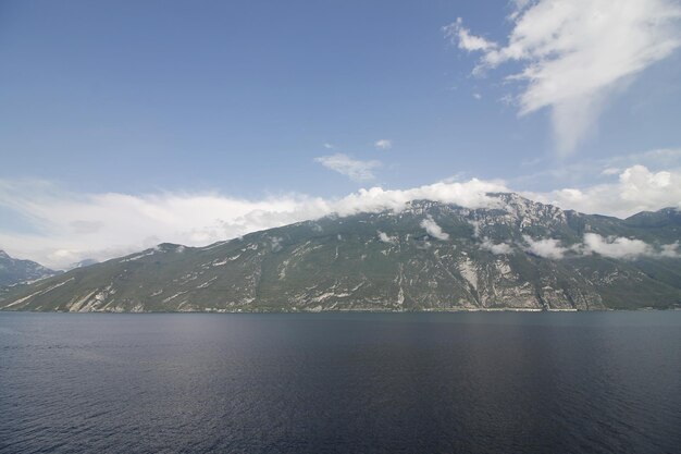 Scenic view of sea by mountains against sky