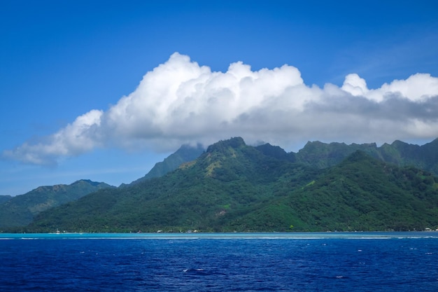 Scenic view of sea by mountains against sky