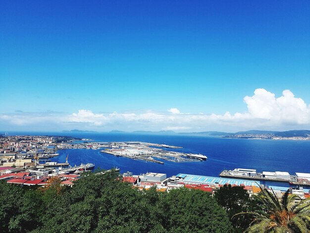 Scenic view of sea by town against blue sky