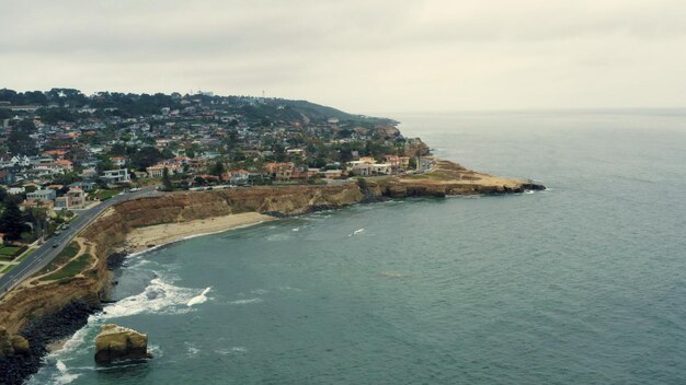 Scenic view of sea by townscape against sky