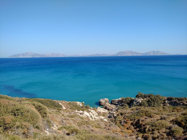 Scenic view of sea and hill against sky