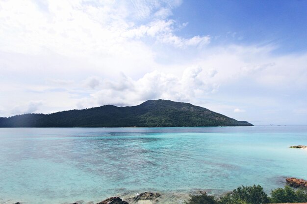 Scenic view of sea and mountains against blue sky