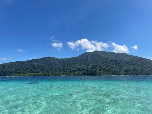 Scenic view of sea and mountains against blue sky