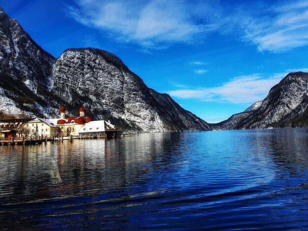 Scenic view of sea and mountains against blue sky