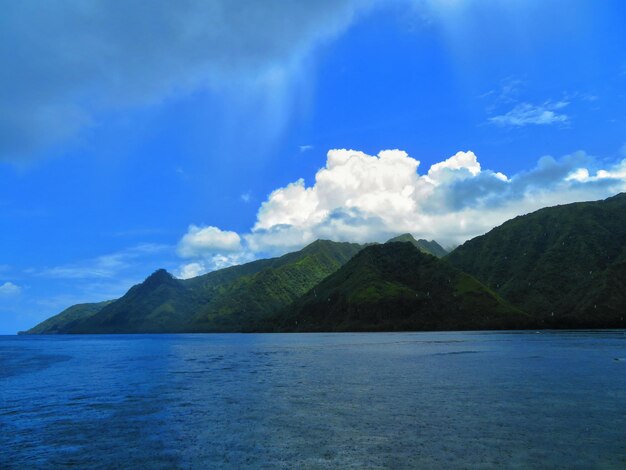 Scenic view of sea and mountains against blue sky