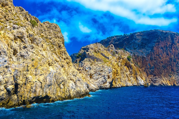 Scenic view of sea and mountains against blue sky