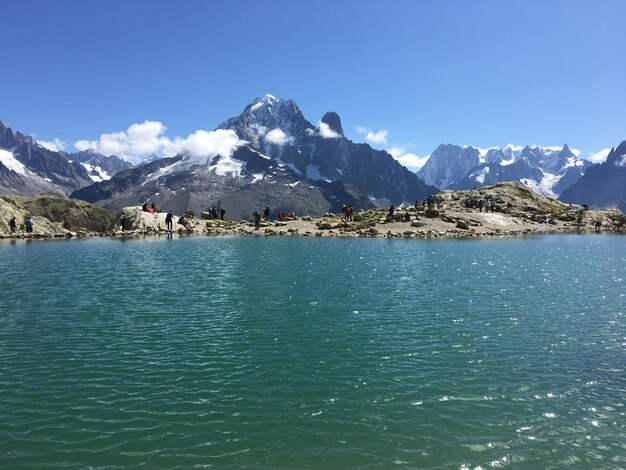 Photo scenic view of sea and mountains against blue sky