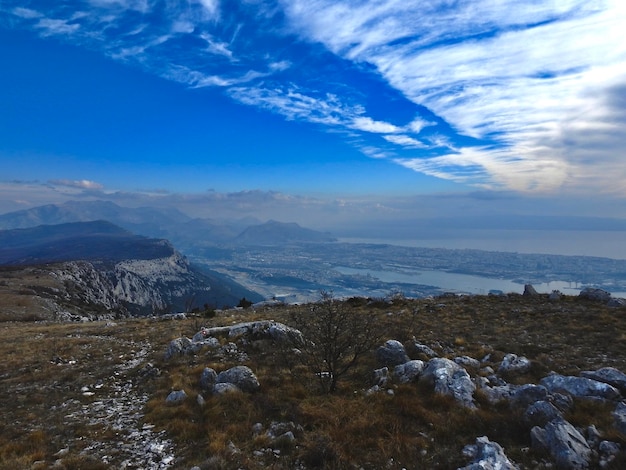 Scenic view of sea and mountains against blue sky