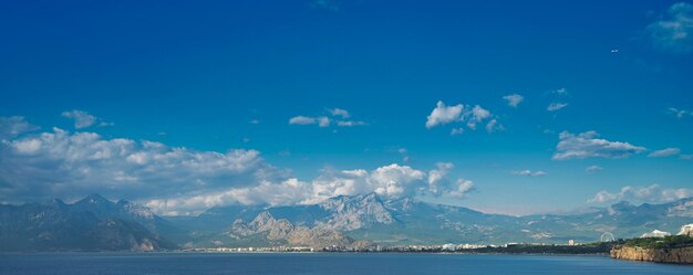 Scenic view of sea and mountains against blue sky