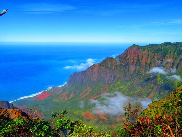 Photo scenic view of sea and mountains against blue sky