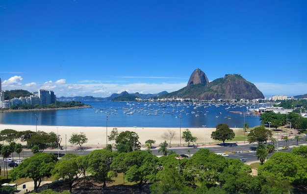 Scenic view of sea and mountains against clear blue sky