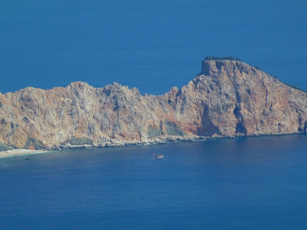 Scenic view of sea and mountains against clear blue sky