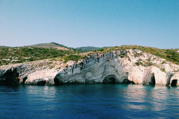 Foto la vista panoramica del mare e delle montagne contro un cielo blu limpido