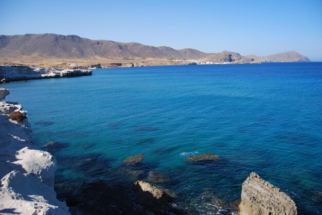 Foto la vista panoramica del mare e delle montagne contro un cielo blu limpido