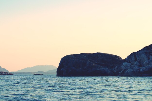 Scenic view of sea and mountains against clear sky