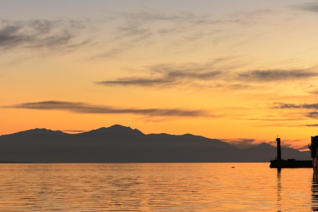 夕暮れの空に照らされた海と山の景色