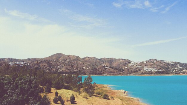 Scenic view of sea and mountains against sky