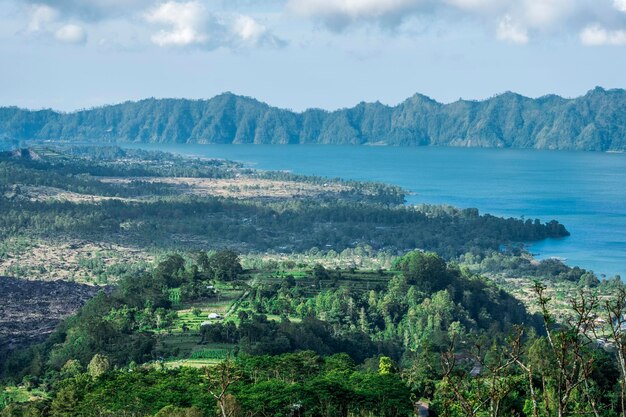 Photo scenic view of sea and mountains against sky