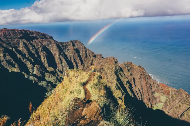 Photo scenic view of sea and mountains against sky