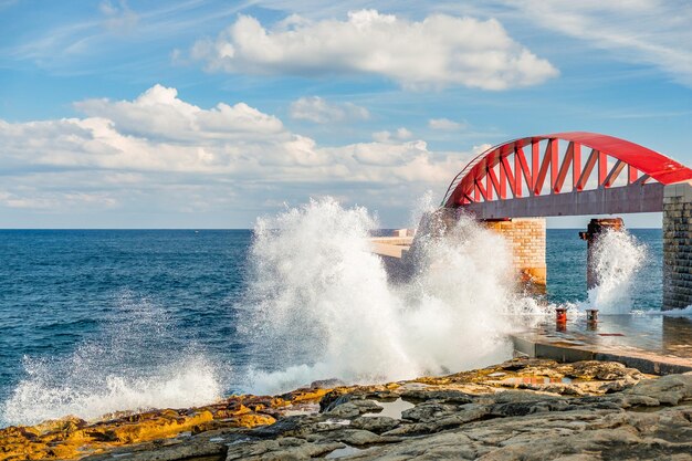 Foto la vista panoramica delle onde del mare che schizzano sulle rocce