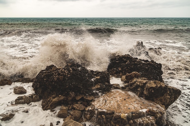 Foto la vista panoramica delle onde del mare che schizzano sulla riva