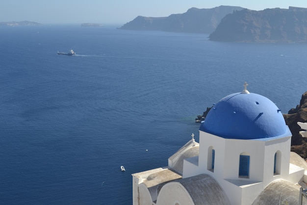 Scenic view of sea with a blue domed greek church on the foreground