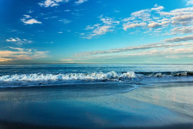 Scenic view of sea with crashing waves against sky