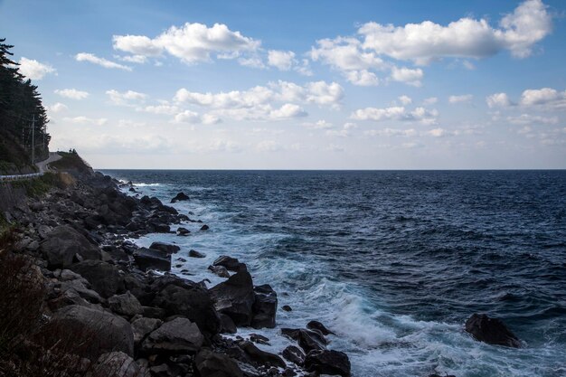 Scenic view of sea with rocky shore against sky