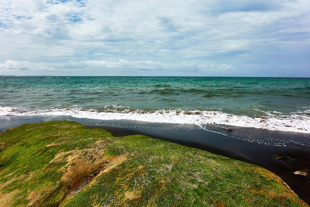 Scenic view of sea with splashing waves against sky